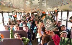 children holding book for one book school reading program