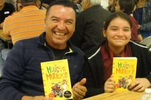 Father and daughter holding copies of The Mouse and the Motorcycle by Beverly Cleary 